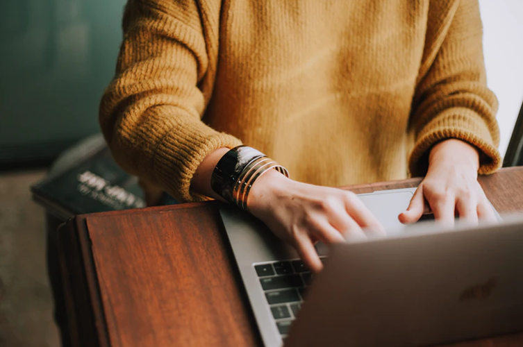 A Person Typing On A Laptop