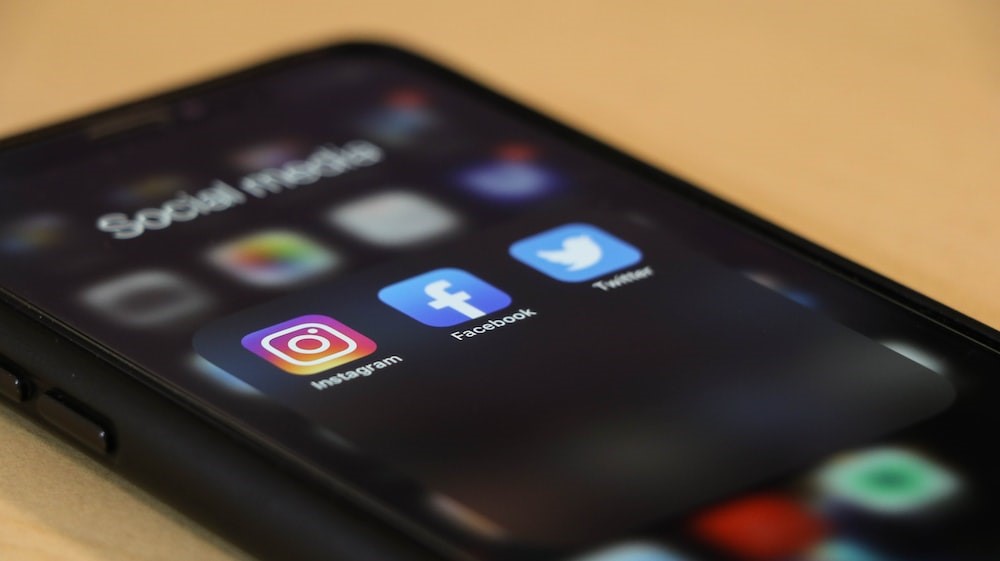 A phone screen with the social media apps Instagram, Facebook, and Twitter in focus