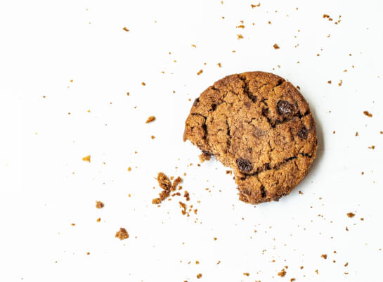 A crumbled chocolate chip cookie with a bite taken out of it